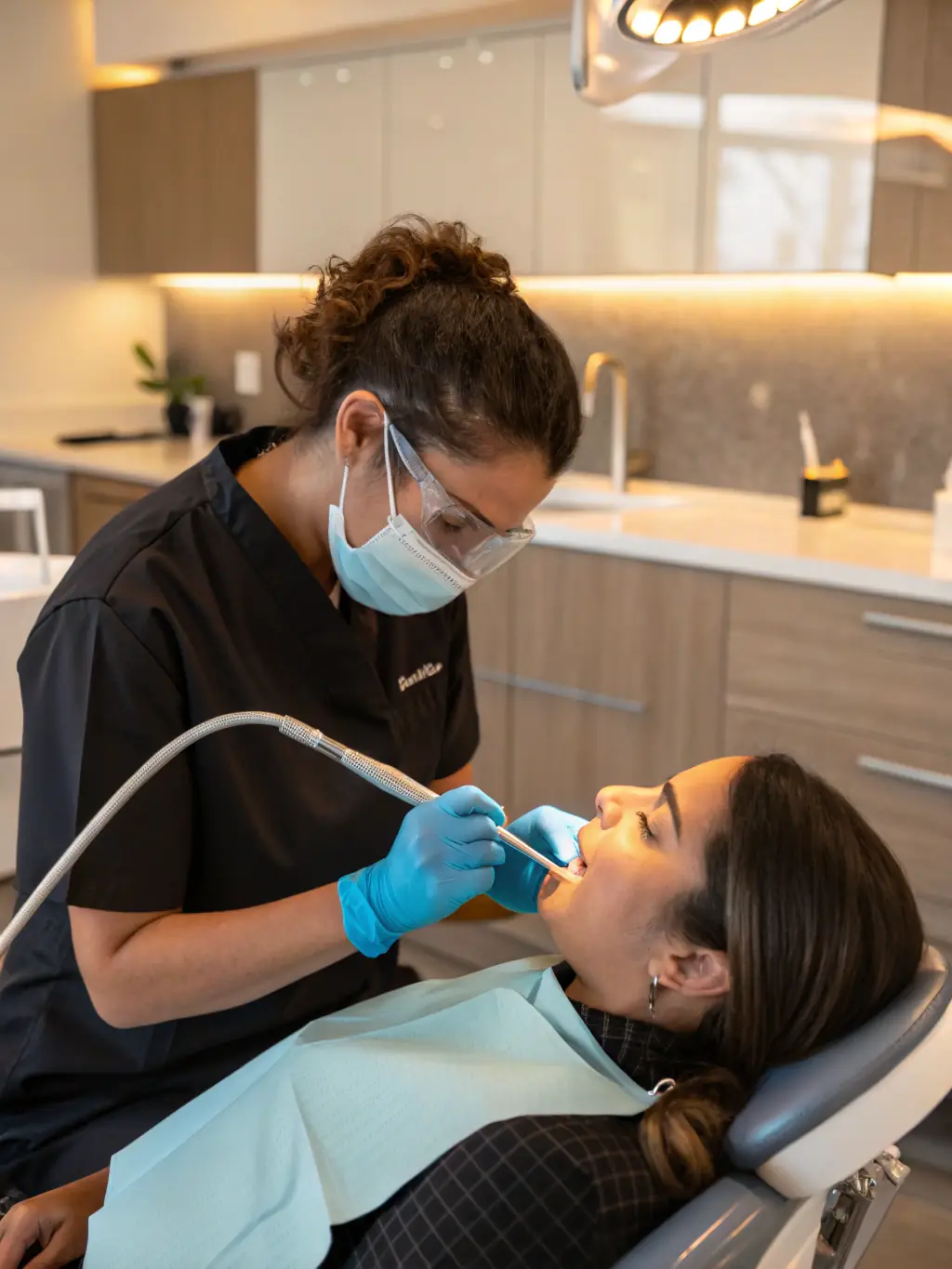 A dental hygienist applying fluoride treatment to a patient's teeth, illustrating the protective benefits of fluoride in preventing tooth decay.