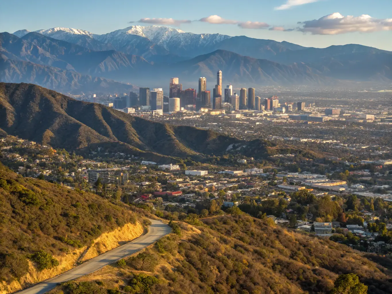 A cityscape of Los Angeles, California, featuring the Hollywood sign and sunny skies.